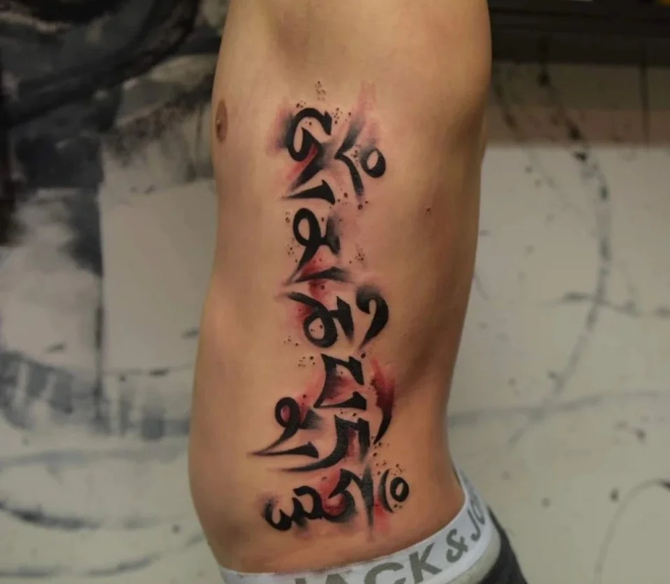 Klassisches Lettering-Tattoo mit asiatischen Schriftzeichen, sauber umgesetzt von Kim im Living Pictures Studio.