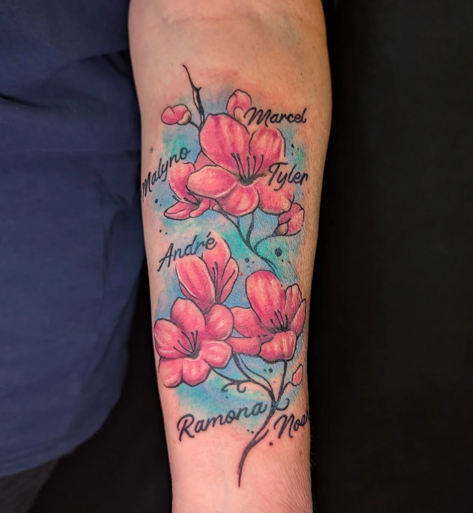Farbstarkes Kirschblüten-Tattoo mit kunstvollem Hintergrund, professionell gestochen von Kim bei Living Pictures Böblingen.