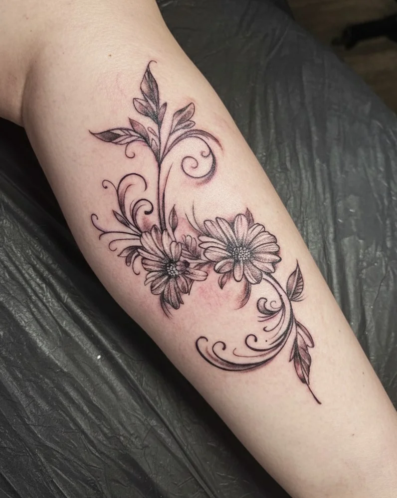 Elegantes Blumen-Tattoo im Fineline-Stil mit zarten Schnörkeln von Artist Lutz, Living Pictures.