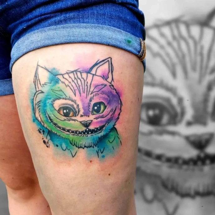 Farbenfrohes Watercolor Tattoo mit einer Grinsekatze auf dem Oberschenkel – kreative Hautkunst in Böblingen.